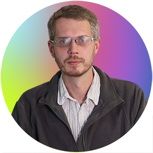 Auf dem Bild ist Herr Guido Ziggel. Sie trägt einen grauen Pullover mit Reißverschluss.